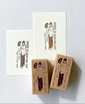 Two rubber stamps with illustrations of a person and text on a light gray background
